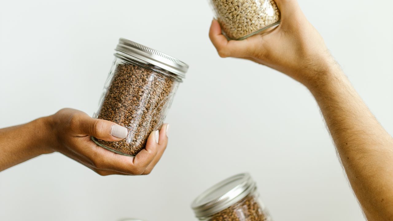 Hands holding jars of hand-picked organic grains and spices